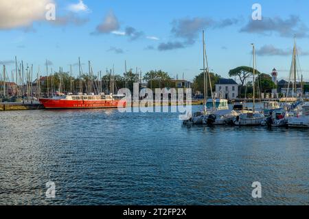 Die rote Fähre nach l'île de Ré im Abendlicht in der wunderschönen Küstenstadt La Rochelle an der Westküste Frankreichs mit Yachten und Fischerbooten. Stockfoto