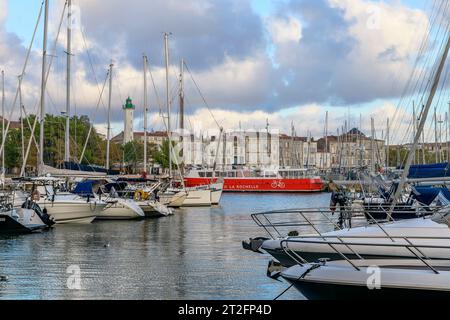 Die rote Fähre nach l'île de Ré im Abendlicht in der wunderschönen Küstenstadt La Rochelle an der Westküste Frankreichs mit Yachten und Fischerbooten. Stockfoto