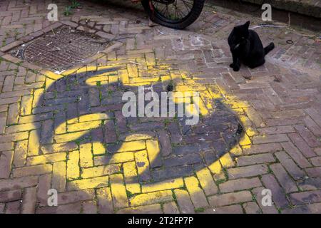 Zierikzee auf der Halbinsel Schouwen-Duiveland, Katze sitzt vor einem Batman-Logo auf der Krepelstraat, Zeeland, Niederlande. Zierikzee auf der Insel SC Stockfoto