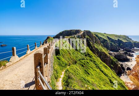 La Coupee, eine schmale Landenge mit der Straße, die Greater Sark an einem sonnigen Spätsommer/Frühsommertag mit Little Sark, Sark, Kanalinseln verbindet Stockfoto