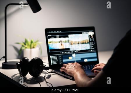 Videobearbeitung mit Filmeditor. Filme mit dem Computer machen. Kopfhörer und Laptop. Sound-, Audio- und Musikdesigner. Mann, der mit der Inhaltsproduktion arbeitet. Stockfoto
