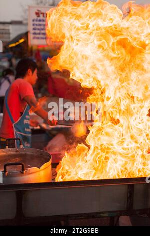 Flammen aus einem Wok, Street Food auf einem Nachtmarkt in Ayutthaya, Thailand Stockfoto