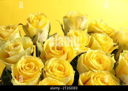 Schöner Rosenstrauß auf gelbem Hintergrund, Nahaufnahme Stockfoto