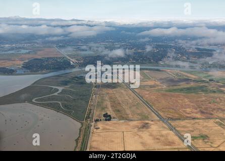 Aus der Vogelperspektive überqueren Straßen und Wasserstraßen die landwirtschaftlichen Felder des Sacramento River Delta Stockfoto