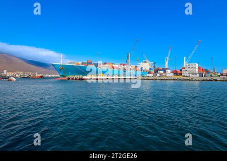 Container, die im Hafen von Iquique auf ein Frachtschiff geladen werden. Stockfoto