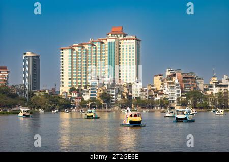 Auf dem Truc Bach Lake neben dem Pan Pacific Hotel in Hanoi, Vietnam, fahren die Menschen schwanförmige Tretboote Stockfoto