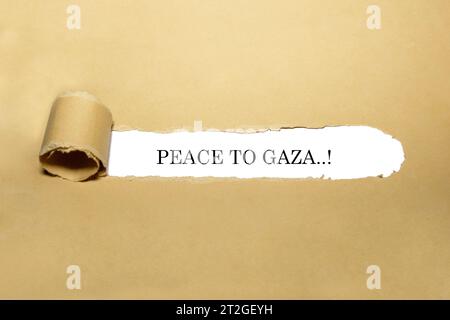 Textziffer von "Frieden für gaza", der hinter zerrissenem braunem Papier erscheint. Stockfoto