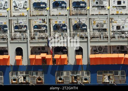 Containerschiffe mit orangefarbenen Schutzbarrieren gegen Piraterie und Metallgitter und Gitterrosten, die in allen Öffnungen im Heckteil verschweißt sind. Stockfoto