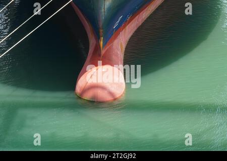 Roter Knollenbogen und blauer Rumpf des Containerschiffs in Detailansicht. Stockfoto
