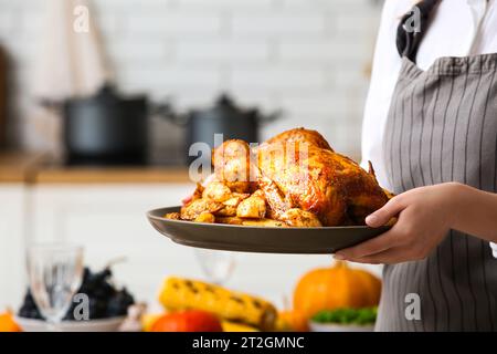 Frau mit leckerem truthahn zum Thanksgiving-Tag in der Küche, Nahaufnahme Stockfoto