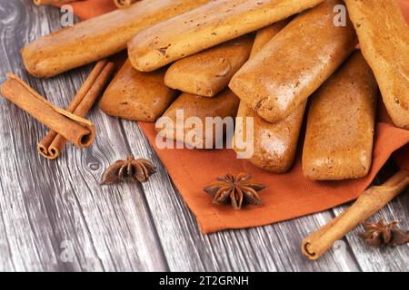 Plätzchen mit Anis und Zimtstangen auf braunem Tuch auf Holztisch. Stockfoto
