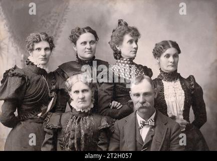 Familienfoto in einem amerikanischen Fotostudio. Der Vater trägt eine quadratische Freimaurernadel. Stockfoto