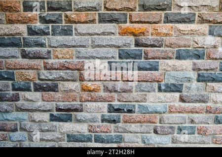 Textur aus schönen mehrfarbigen rechteckigen Ziegeln, Fliesen aus natürlichem Marmor und Granitsplittern mit Nähten. Der Hintergrund. Stockfoto