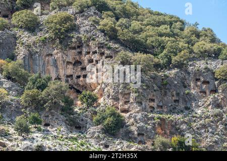 Klippen mit Honigwaben und Felsengräbern überragt die antike Stätte Pinara in der Provinz Mugla in der Türkei. Pinara war eine große Stadt im antiken Lykien. Stockfoto