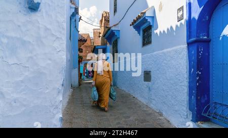 Chefchaouen, Marokko - 11. September 2022: Frau zu Fuß in Chefchaouen, bekannt als die blaue Stadt, berühmt für ihre auffällige blaue Farbe bemalt Medina buil Stockfoto