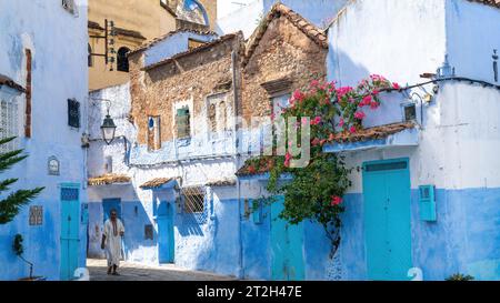 Chefchaouen, Marokko - 11. September 2022: Man Walking in Chefchaouen, bekannt als die blaue Stadt, berühmt für ihre auffällige blaue Farbe gemalt Medina Buildi Stockfoto