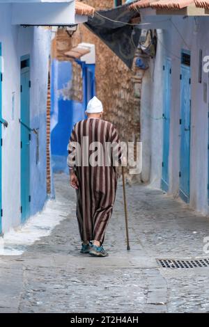 Chefchaouen, Marokko - 11. September 2022: Ein alter Mann wandert in Chefchaouen, bekannt als die blaue Stadt, berühmt für ihre auffällige blaue Farbe gemalt Medina Bu Stockfoto