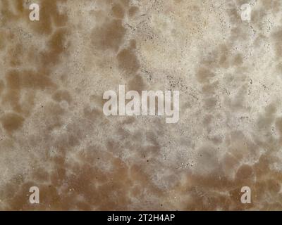 Abstrakter Hintergrund aus gelbem Marmor an der Wand mit Sonnenlicht. Stockfoto