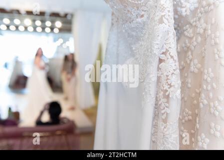 Braut, um verschiedene Brautkleider anzuprobieren, um zu sehen, welcher Spitzenstil am besten aussieht. Stockfoto
