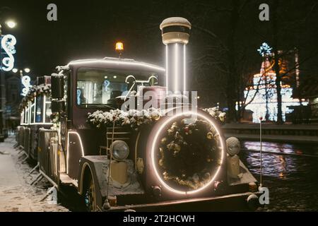 Weihnachtszug und wunderschön dekorierter Weihnachtsbaum auf dem Domplatz von Vilnius, Litauen Stockfoto