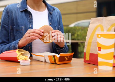 Lviv, Ukraine - 9. Oktober 2023: Frau mit McDonald's Menü am Tisch draußen, Nahaufnahme Stockfoto