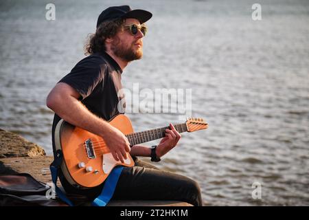 Straßenmusiker, der auf der Straße Gitarre spielt Stockfoto