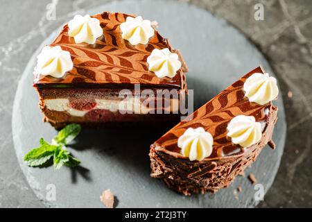 Kirschtorte aus schwarzem Wald mit genuesischem Schokoladenschwamm, cremiger Ganache, glänzender dunkler Schokoladenglasur und Chantilly-Creme. Stockfoto