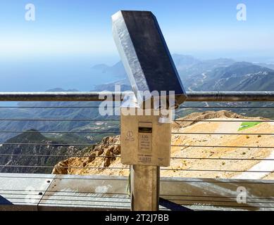 Fernglas auf einer Aussichtsplattform aus grauem und dichtem Metall. Besichtigungstour, Beobachtung der Aussicht von den Bergen unten. Die Schönheit eines Trop Stockfoto