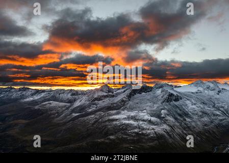 Leuchtende Wolken bei Sonnenaufgang über dem Ramolhaus mit Blick auf den wolkenbedeckten Hauptkamm der Ötztaler und Stubaier Alpen, Gurgler Tal, Ötztaler Alpen, Tirol Stockfoto