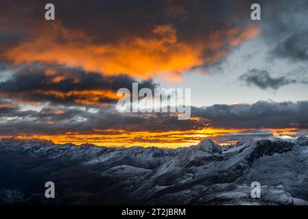 Leuchtende Wolken bei Sonnenaufgang über dem Ramolhaus mit Blick auf den wolkenbedeckten Hauptkamm der Ötztaler und Stubaier Alpen, Gurgler Tal, Ötztaler Alpen, Tirol Stockfoto