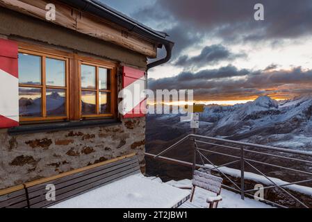 Leuchtende Wolken bei Sonnenaufgang über dem Ramolhaus mit Blick auf den wolkenbedeckten Hauptkamm der Ötztaler und Stubaier Alpen, Gurgler Tal, Ötztaler Alpen, Tirol Stockfoto