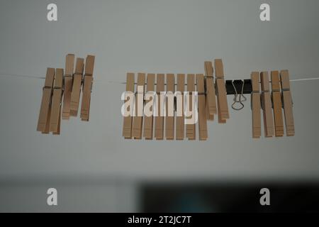 Eine Nahaufnahme einer Reihe von kleinen hölzernen Kleiderschalen, die mit einem Stück Schnur verbunden sind Stockfoto