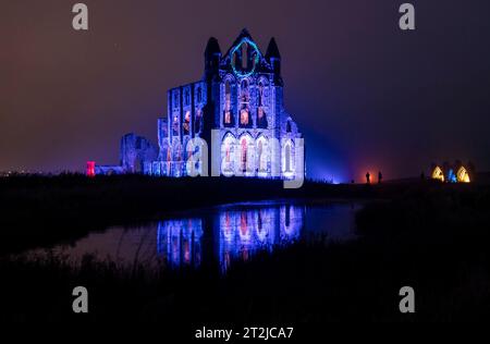 English Heritage beleuchtet die Ruinen von Whitby Abbey in North Yorkshire vor der beleuchteten Abbey. Mit einer ausgedehnten Veranstaltung von zehn Abenden vom 22. Bis 31. Oktober können Besucher in die gruseligen Taten des Ortes eintauchen, der Bram Stoker dazu inspirierte, „Dracula“ zu kreieren. Bilddatum: Donnerstag, 19. Oktober 2023. Stockfoto