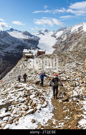 Gruppe von Bergsteigern, die von der Ramolhaus-Hütte zum Ramoljoch vor den frisch verschneiten Bergen der Ötztaler Alpen aufbrechen Stockfoto