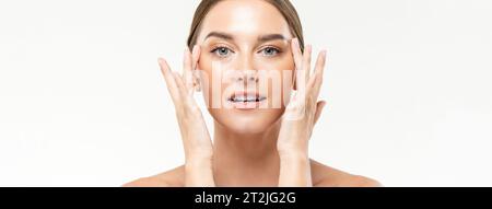 Beauty Shot Portirait des schönen kaukasischen weiblichen Massagegesichts mit Händen auf weißem Banner Hintergrund im Lichtstudio Stockfoto