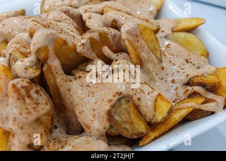 Nahaufnahme von Patatas Bravas, typisch spanischem Gericht mit würziger Sauce. Stockfoto