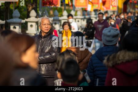 Ein älterer vietnamesischer Mann läuft in Menschenmassen in der Tran Quoc Pagode in Hanoi, Vietnam, in Tet, oder in der Mondneujahr, als er kommt, um für Gesundheit zu beten, W Stockfoto