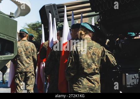 16.08.2023 Warschau, Polen. Außenansicht polnischer Infanterie-Soldaten in Tarnuniformen und grünen Baskenmützen, die während eines militärischen Open-Air-Ereignisses Flaggen von Polen halten. Hochwertige Fotos Stockfoto