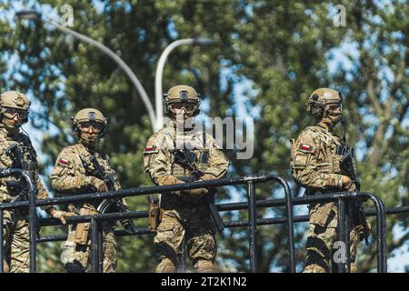 16.08.2023 Warschau, Polen. Selbstbewusste, voll bewaffnete polnische Soldaten in Tarnuniformen, die in die Kamera schauen und auf einer Plattform stehen. Spezialeinsatzkommando auf einem Leiterwagen. Hochwertige Fotos Stockfoto