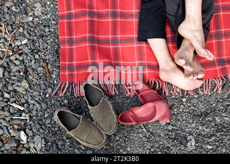 Ein Paar Füße verwickelt auf einer roten Decke. Stockfoto