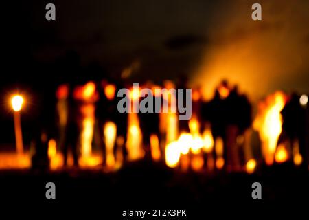 Eine Gruppe versammelte sich um ein Lagerfeuer am Ufer des Sebago Sees. Stockfoto