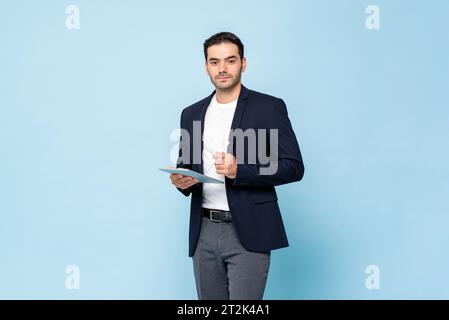 Intelligenter gutaussehender kaukasischer Mann im halbformalen Business-Anzug, der Tablet-Computer mit Stift in hellblauer Farbe isoliert Studiohintergrund hält Stockfoto