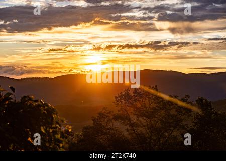 Die Sonne untergeht durch die Wolken über den Blue Ridge Mountains Stockfoto