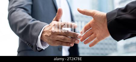 Bannerbild der Hände von Geschäftsleuten, die in der Stadt den Handschlag für das Fusions- und Übernahmekonzept machen Stockfoto