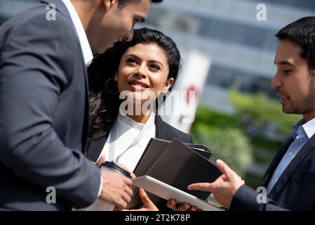 Asiatisches Business-Team in Firmenkleidung trifft sich und spricht draußen in der Stadt Stockfoto