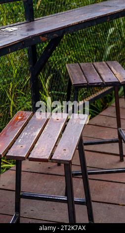 Die Stühle und Tische in diesem braunen Garten sind aus Holz und Eisen für die Beine Stockfoto