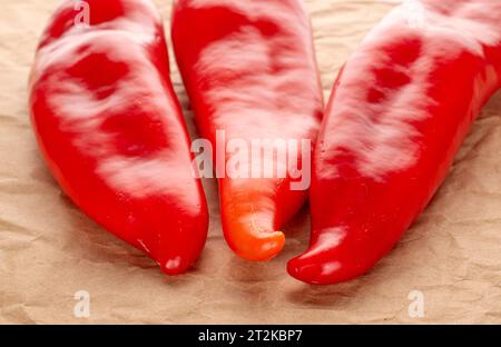 Drei rote Paprika mit Kraftpapier Stockfoto