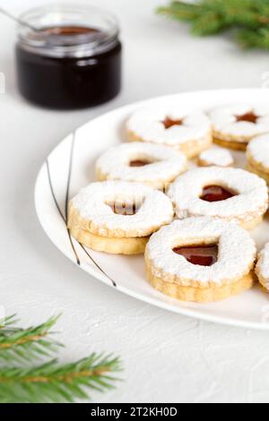 Hausgemachte Linzer Shortbread Plätzchen mit Marmelade bestreut mit Puderzucker auf weißem Teller. Weihnachten festlich schöne Weihnachtsgebäck, süße Leckereien. C Stockfoto