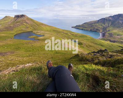 Wanderer genießen die Aussicht von der Spitze eines Berges in Islands Ostfjorden Stockfoto