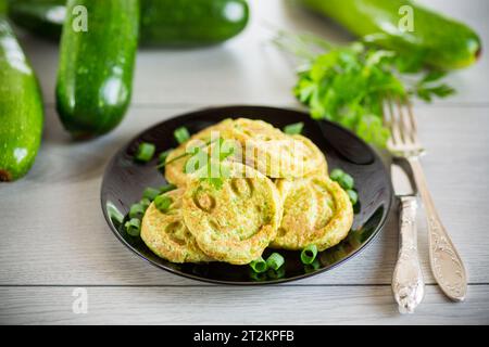 Gebratene Kürbiskuchen auf einem Teller, auf einem Holztisch. Stockfoto